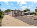 Cozy single-story home with a detached garage and well-kept landscaping, on a sunny day at 5445 Reed Ct, Arvada, CO 80002