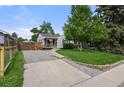 Landscaped front yard with a well-maintained lawn and a concrete driveway leading to the charming home at 5115 Osceola St, Denver, CO 80212