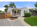 Charming home with a welcoming front porch, complemented by lush greenery and landscaping at 5115 Osceola St, Denver, CO 80212