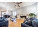 Open-concept living room with a cozy fireplace, hardwood floors, and abundant natural light at 4059 Quivas St, Denver, CO 80211