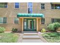 Inviting apartment entrance with a green awning and well-maintained landscaping at 2100 N Franklin St # 8, Denver, CO 80205