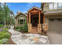 Covered entry features wood beam columns, stone accents, and a pathway to the front door at 1456 Shavano Ct, Evergreen, CO 80439