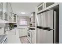 Modern white kitchen featuring stainless steel appliances and stylish backsplash at 352 S Lafayette St # 204, Denver, CO 80209