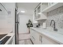 Bright kitchen boasts white cabinetry, stainless appliances, and stylish mosaic backsplash at 352 S Lafayette St # 204, Denver, CO 80209