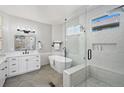 Bright bathroom with double vanity, soaking tub, and glass-enclosed shower with modern fixtures at 1053 Snow Lily Ct, Castle Pines, CO 80108