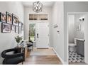 Bright entryway featuring modern decor, a statement light fixture, and a convenient half-bathroom at 1053 Snow Lily Ct, Castle Pines, CO 80108