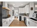 Modern kitchen with white cabinets, stainless steel appliances, and hardwood flooring at 1053 Snow Lily Ct, Castle Pines, CO 80108