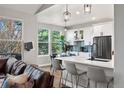 Bright kitchen with white cabinets, stainless steel appliances, and hardwood floors opens up to dining area at 1053 Snow Lily Ct, Castle Pines, CO 80108