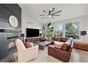 Cozy living room featuring a fireplace, leather sofa, and views of the outdoors at 1053 Snow Lily Ct, Castle Pines, CO 80108