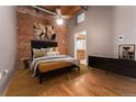 Cozy bedroom showcases exposed brick wall, hardwood floors, and ample closet space at 2960 Inca St # 308, Denver, CO 80202