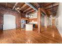 Spacious living space with hardwood floors and exposed brick, leading into an open kitchen at 2960 Inca St # 308, Denver, CO 80202