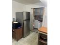 Functional kitchen with stainless steel refrigerator and a view into a laundry area for added convenience at 1132 Moline St, Aurora, CO 80010