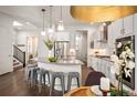 Modern kitchen featuring white cabinetry, stainless steel appliances, and an island with bar seating at 9007 E 60Th Ave, Denver, CO 80238