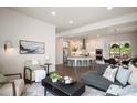 Bright and airy living room flowing into a modern kitchen with a large island and stainless steel appliances at 9007 E 60Th Ave, Denver, CO 80238