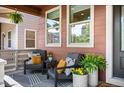 Inviting covered porch with stylish seating, decorative pillows, and potted plants for a cozy outdoor space at 9007 E 60Th Ave, Denver, CO 80238
