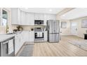 Modern kitchen with white cabinets, stainless steel appliances, and ample counter space for cooking at 7380 Utica St, Westminster, CO 80030