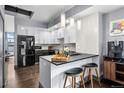 Stylish kitchen featuring modern white cabinets, black countertops, and a breakfast bar with seating at 2539 Lawrence St, Denver, CO 80205