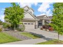 Beautifully landscaped home featuring lush greenery, stone accents, and a spacious driveway at 5077 W 108Th Cir, Westminster, CO 80031