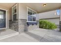 Inviting front porch with stone detailing and a window box, perfect for enjoying the outdoors at 5077 W 108Th Cir, Westminster, CO 80031