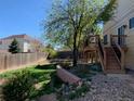 A backyard with a wood deck, fence, some grass and landscaping at 3824 S Quemoy Way, Aurora, CO 80018