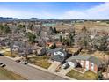 Scenic aerial view of a residential neighborhood, showcasing houses, streets, and a lake in the distance at 7515 W Polk Ave, Littleton, CO 80123