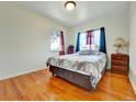 Cozy bedroom with hardwood floors, natural light from the window, and a comfortable bed at 675 S Quivas St, Denver, CO 80223