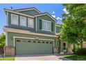 Two-story home featuring a two-car garage, light brick accents, and lush lawn at 19466 E 59Th Dr, Aurora, CO 80019