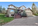 Charming home with a two-car garage, landscaped front yard, and inviting front porch area at 31402 N Bermuda Dunes Dr, Evergreen, CO 80439