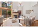 Bright living room with a stone fireplace, large windows, and stylish decor at 31402 N Bermuda Dunes Dr, Evergreen, CO 80439