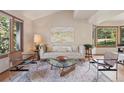 Inviting living room with stylish seating, a glass coffee table, and views of the surrounding greenery at 31402 N Bermuda Dunes Dr, Evergreen, CO 80439