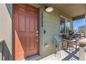 Inviting front porch with a cozy seating area and a well-lit entrance at 12794 Tamarac St, Thornton, CO 80602
