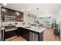 Modern kitchen with stainless steel appliances, an island, and an open floor plan at 12794 Tamarac St, Thornton, CO 80602