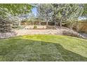 A beautifully landscaped backyard with a tiered stone retaining wall and a lush green lawn at 10908 Oakshire Ave, Highlands Ranch, CO 80126