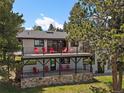 Multi-level deck featuring black railings and red chairs create an inviting outdoor living space at 31756 Buffalo Park Rd, Evergreen, CO 80439