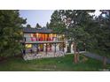 Beautiful two-story house with stone facade, upper and lower decks and red patio chairs at 31756 Buffalo Park Rd, Evergreen, CO 80439