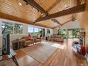 Spacious living room with wood ceiling, fireplace, hardwood floors, and sliding doors to deck at 31756 Buffalo Park Rd, Evergreen, CO 80439