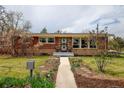 Charming brick home featuring a well-manicured front yard and walkway, inviting curb appeal at 345 Central Ave, Brighton, CO 80601