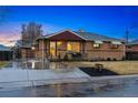 Inviting brick house featuring an attached garage and a cozy front porch at 7131 Raritan St, Denver, CO 80221