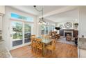 Bright dining area with access to outdoor deck and views of the living area with fireplace, promoting seamless indoor-outdoor living at 19099 E Creekside Dr, Parker, CO 80134