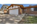 Charming home featuring brick and Tudor accents, an attached garage, and a secure front entry door at 17675 E Girard Ave, Aurora, CO 80013