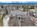 Expansive home with a gray tile roof and mature trees, showcasing the property's setting at 6790 W Crestline Ave, Littleton, CO 80123