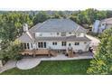 Spacious backyard with a wooden deck, patio, and steps leading to manicured lawn at 6790 W Crestline Ave, Littleton, CO 80123