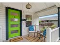 Inviting front porch featuring a green door and cozy seating area at 3052 S Logan St, Englewood, CO 80113