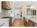 Modern kitchen featuring white cabinets, stainless steel appliances, and a gray tile backsplash at 5145 S Kearney Ct, Greenwood Village, CO 80111