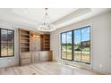Well lit home office with built-in shelving, cabinets, hardwood floors and a large window with backyard views at 5145 S Kearney Ct, Greenwood Village, CO 80111