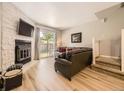 Cozy living room features a stone fireplace, modern flooring, and backyard access at 9736 W Cornell Pl, Lakewood, CO 80227