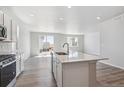 Spacious kitchen boasts white cabinets, stainless appliances, and a large center island at 25023 N 34Th Ave, Aurora, CO 80019