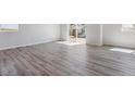 Open-concept living room features gray wood floors and lots of natural light at 25023 N 34Th Ave, Aurora, CO 80019