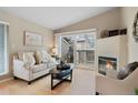 Cozy living room with fireplace and access to the balcony, creating a seamless indoor-outdoor living experience at 8406 Pebble Creek Way # 202, Highlands Ranch, CO 80126