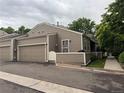 Charming beige townhouse with a two-car garage and inviting outdoor patio area at 5898 W Asbury Pl, Lakewood, CO 80227